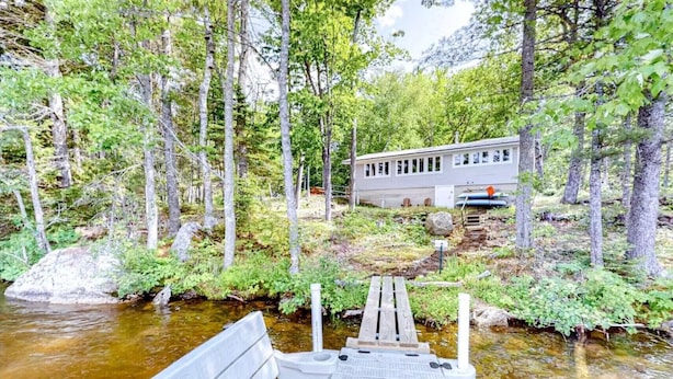 A cabin with a dock extending into a river surrounded by forest. - Quiet Leonard Lake Retreat,  Beautiful Waterfront Home  (Ellsworth)
