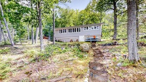 A cabin with a dirt path leading to it, surrounded by trees. - Quiet Leonard Lake Retreat,  Beautiful Waterfront Home  (Ellsworth)