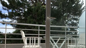 Ein Balkon mit weißen Metallgeländern und einem weißen Stuhl.