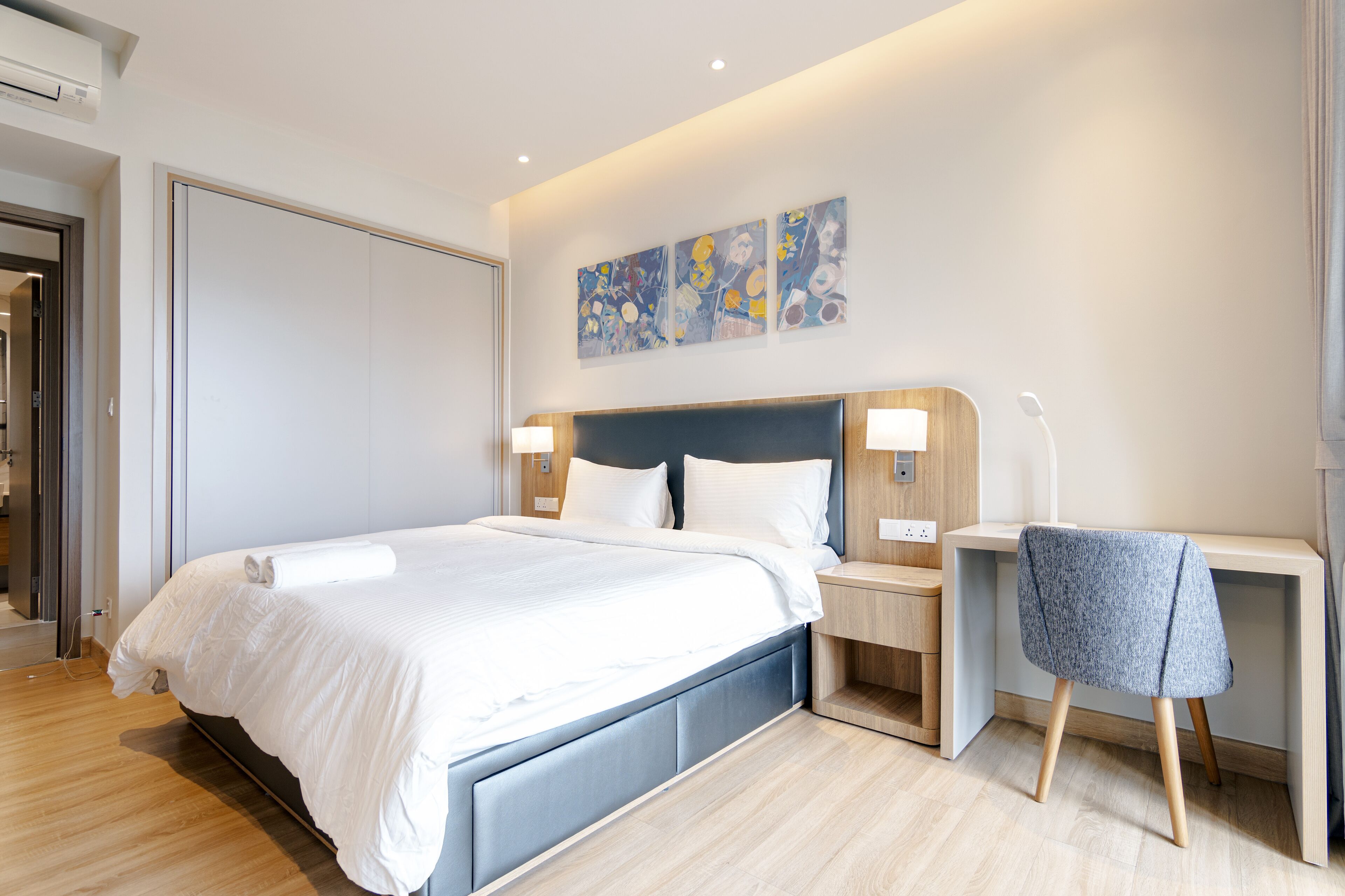 Una habitación de hotel moderna con una cama grande, un escritorio y una silla.