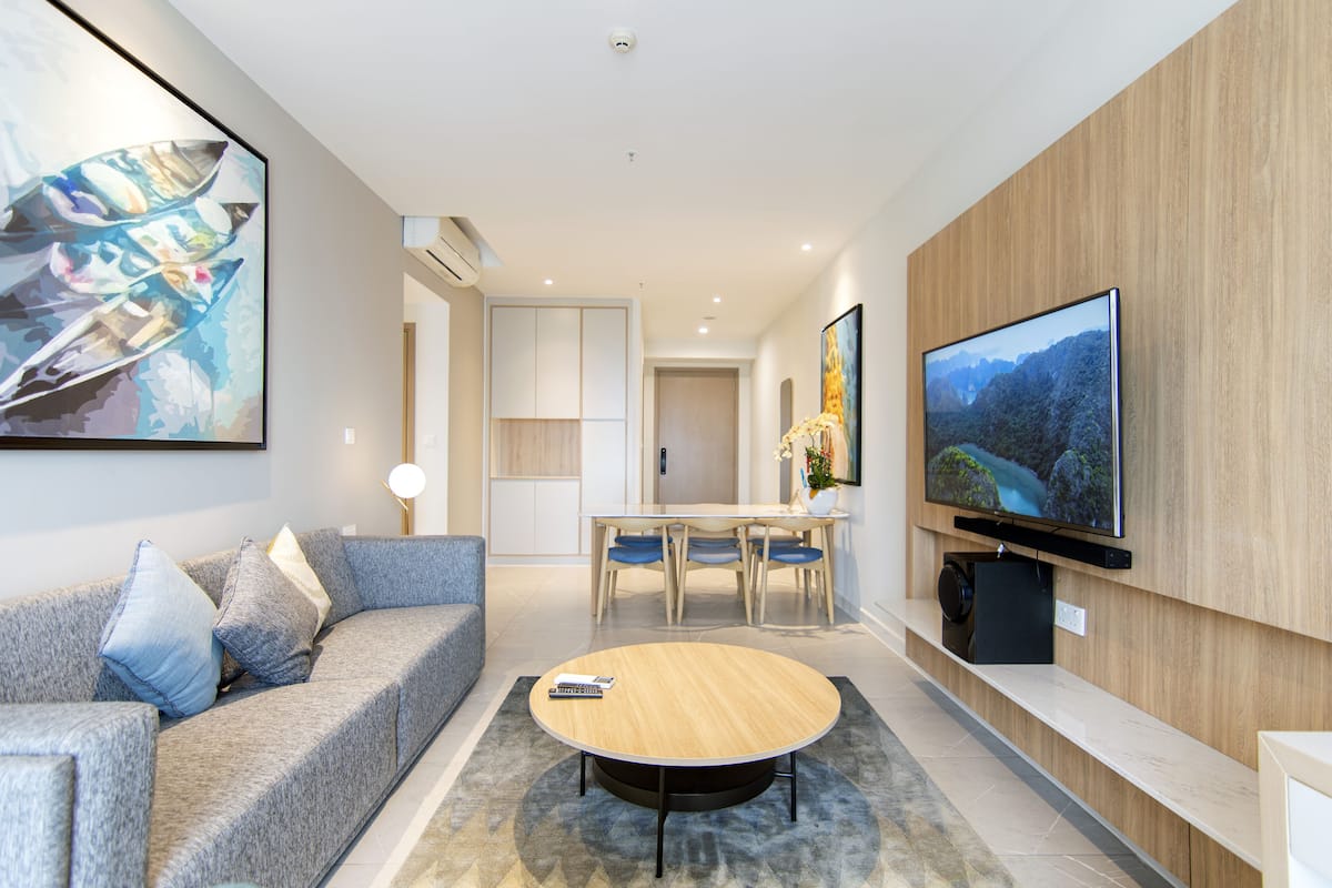 Ein modernes Wohnzimmer mit Sofa, Couchtisch, Fernseher und Kunstwerken.