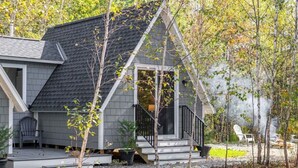 Une maison avec un porche, un escalier et un petit jardin.