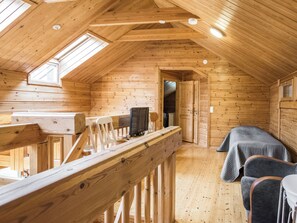 Una cabana de fusta amb un dormitori al menjador, un petit escriptori amb un ordinador i una finestra que donava a l'interior.