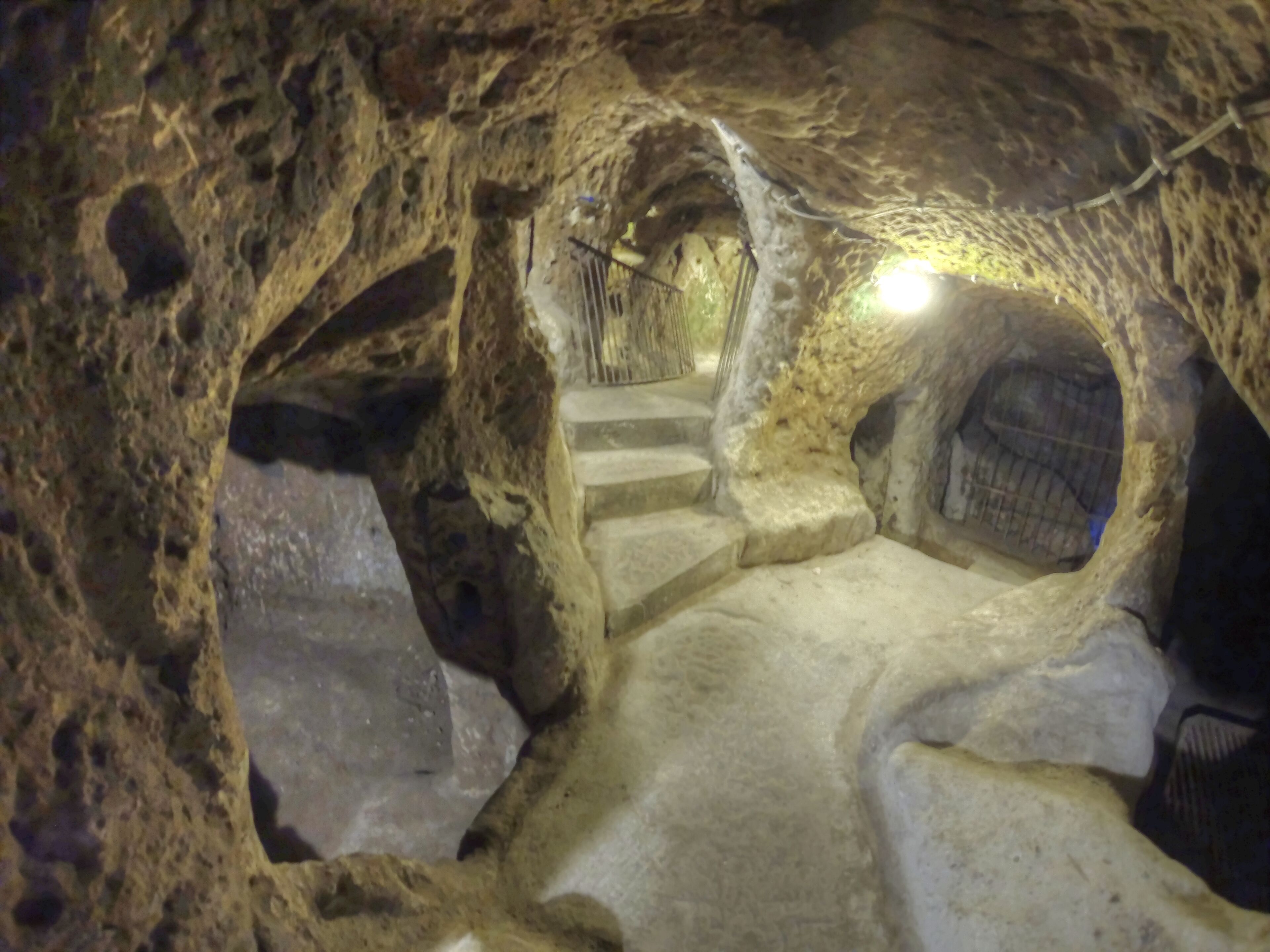 Una escalera de piedra que sube a un nivel superior dentro de una estructura parecida a una cueva.