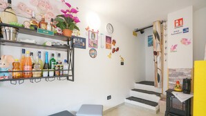 Uma área de bar com prateleiras cheias de garrafas e um relógio na parede.