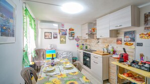 Uma cozinha compacta com área de refeições, apresentando um cantinho do café, pia e fogão.