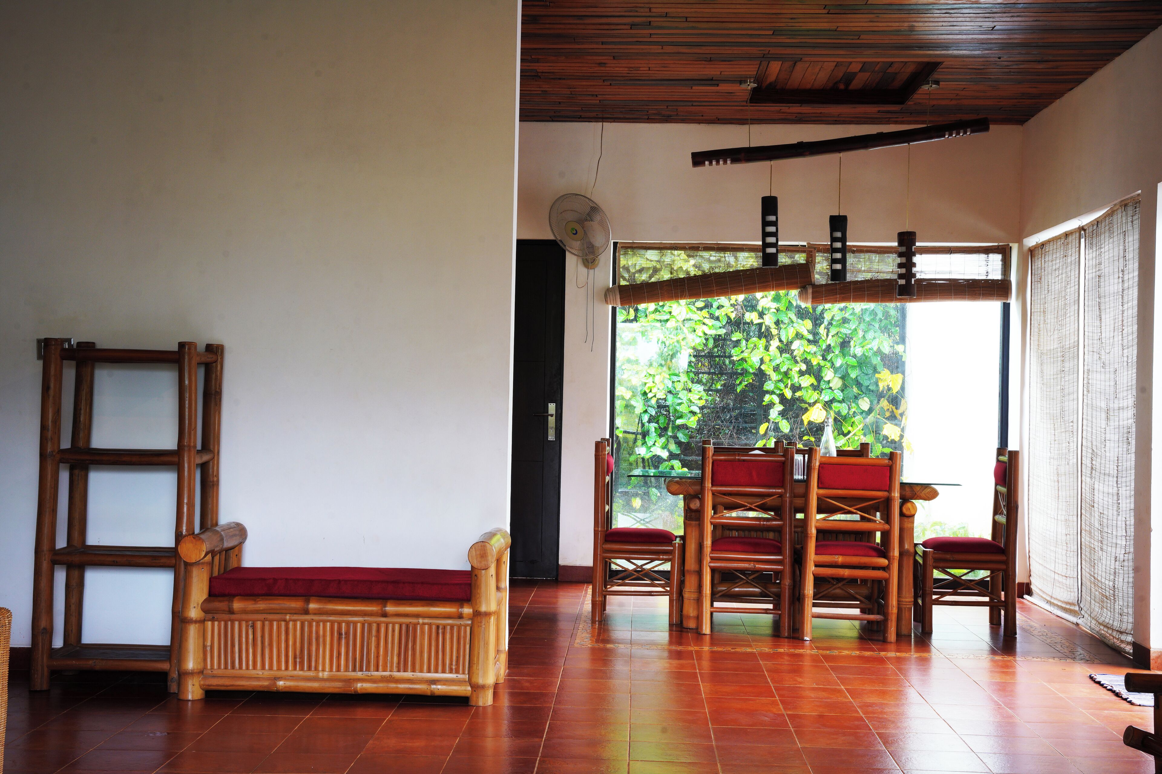 A room with a wooden floor, a wooden bench, and a table with chairs.