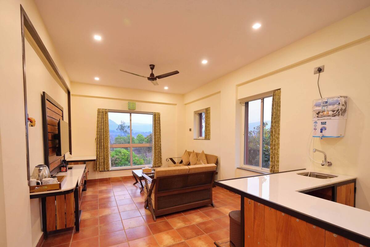 A compact kitchen with a dining area, a ceiling fan, and a view of the outdoors.