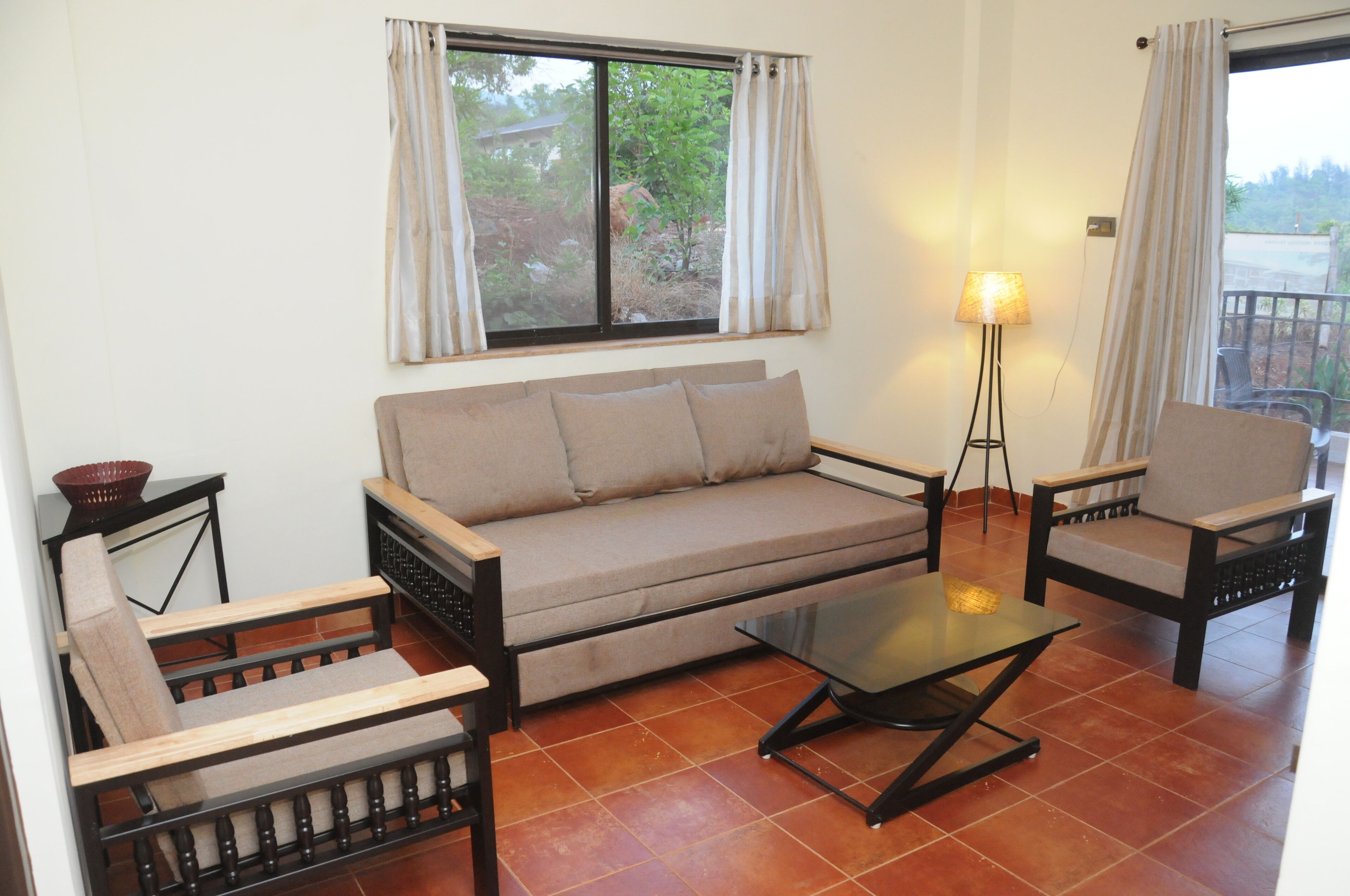 A living room with a sofa, two armchairs, a coffee table, and a floor lamp.