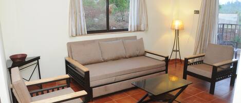 A living room with a sofa, two armchairs, a coffee table, and a floor lamp.