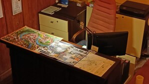 Una habitación con escritorio, silla y mapa.