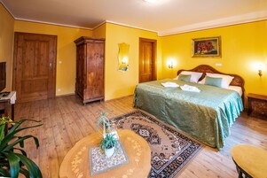Un dormitorio con cama, armario de madera y espejo en la pared.