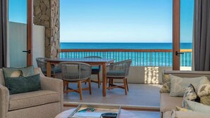 A balcony with a view of the sea, furnished with a sofa, chairs, and a table. - Soleado 312 Oceanfront Condo at Costa Azul Beach! (San José del Cabo)