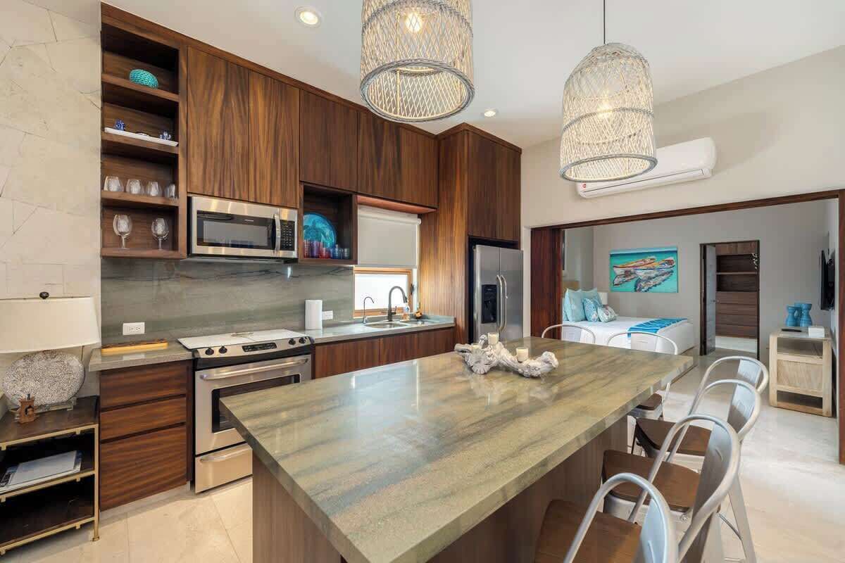 A modern kitchen with wooden cabinets, stainless steel appliances, and a large island.