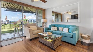 A modern living room with a sofa, armchair, and glass coffee table. - Oceanfront Beachfront Escape Hale Kai 1Bed (Lahaina)