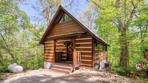 Eine Holzhütte mit Holzfassade, einer Veranda und einem Steinweg, der zum Eingang führt.