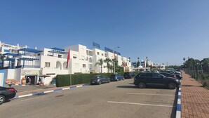 Un hotel con reception, parcheggio e un cielo azzurro intenso.