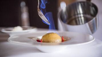 Ein Dessert mit einem Löffel blauem Feuer auf einem weißen Teller.