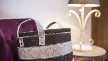Un bolso a rayas grises y negras con una hebilla metálica y un asa, sobre un sofá morado.