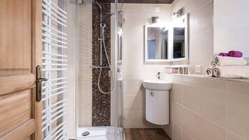 A bathroom with a shower, a sink, and a mirror.