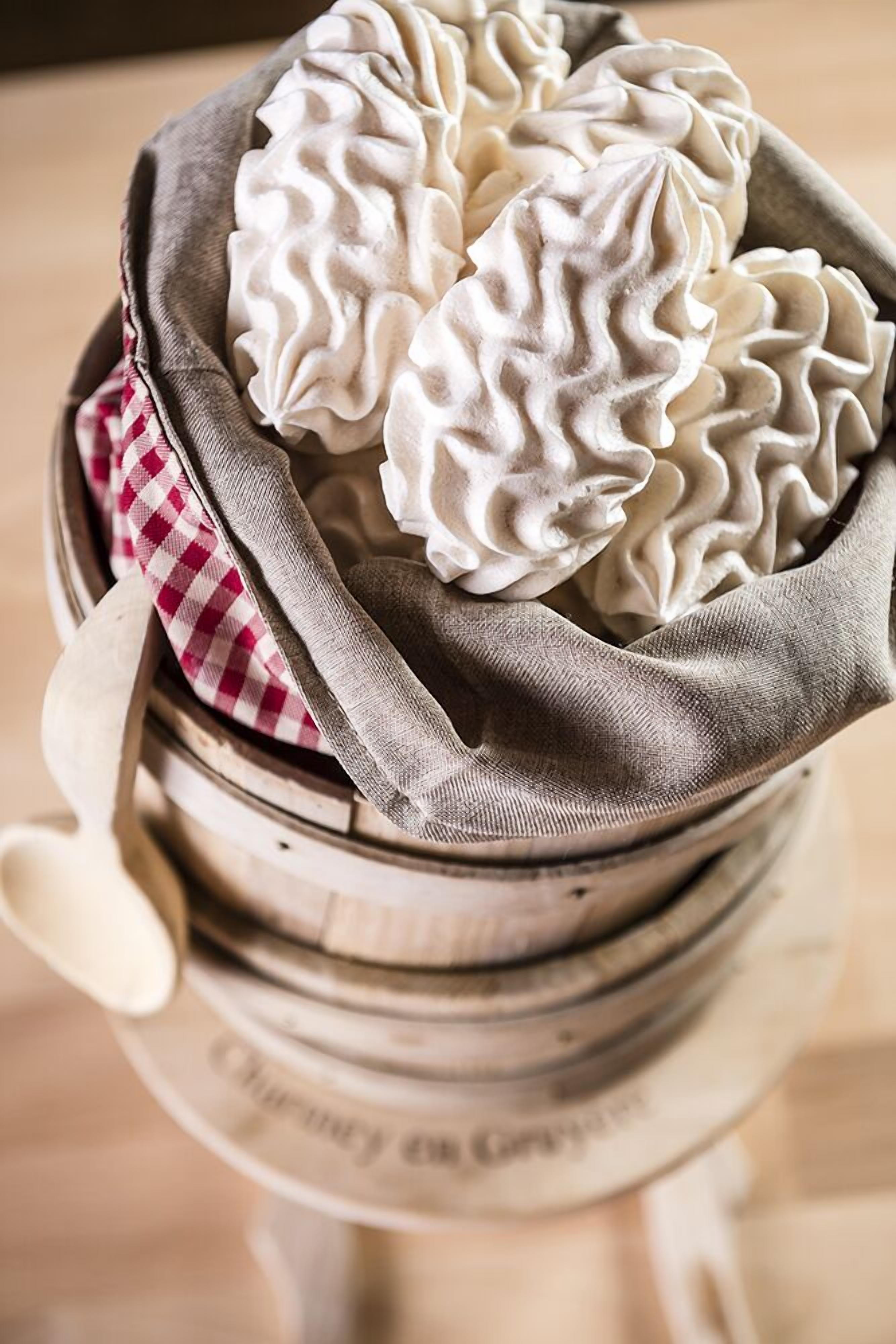 Un panier de raviolis blancs et plissés, posé sur une surface en bois.