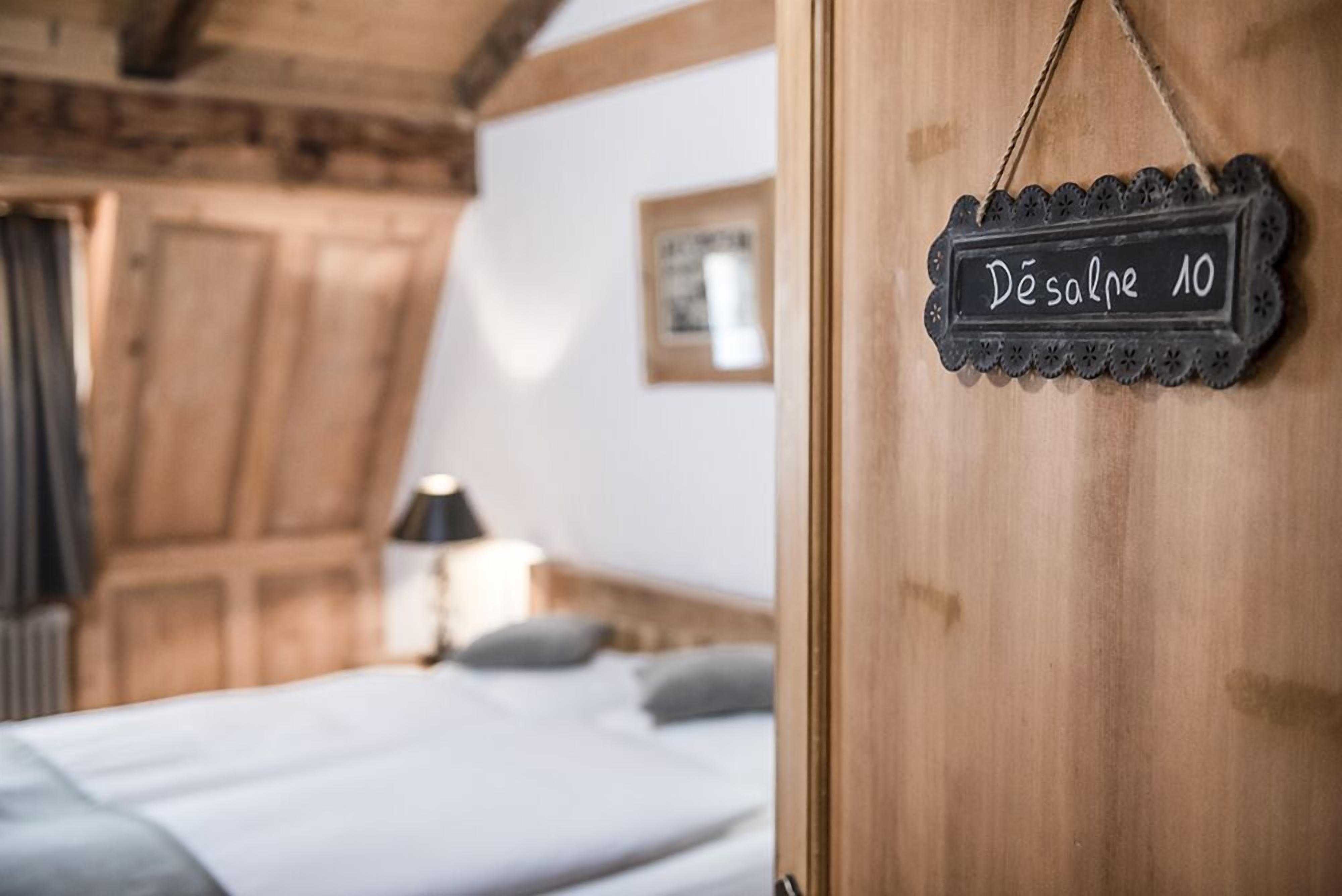 Un dormitorio acogedor con techo de madera, cama con ropa blanca y un cartel que dice 