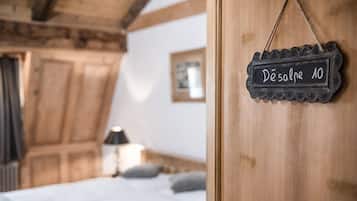 Un dormitorio acogedor con techo de madera, cama con ropa blanca y un cartel que dice