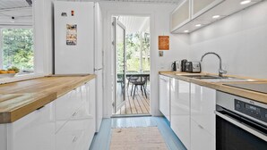 A modern kitchen with white cabinetry, a wooden countertop, and a stainless steel sink. - Awesome home in Højby with WiFi (Højby)
