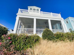 A two-story house with a balcony and a covered porch.