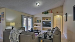 A living room with two sofas, a TV, and a coffee table. - Cozy Nook Villa w/ Pool: 10 Mi to Park Entrance! (Clermont)