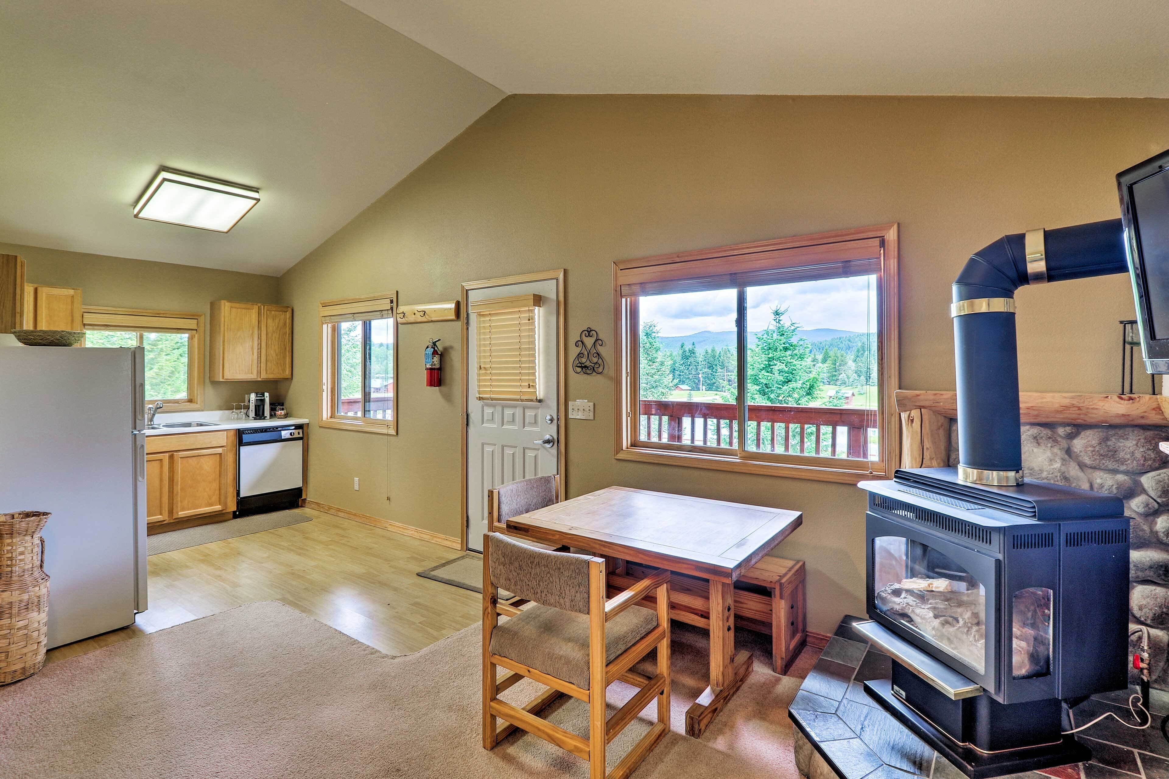 A kitchen with a dining area, a stove, and a view of the outdoors.