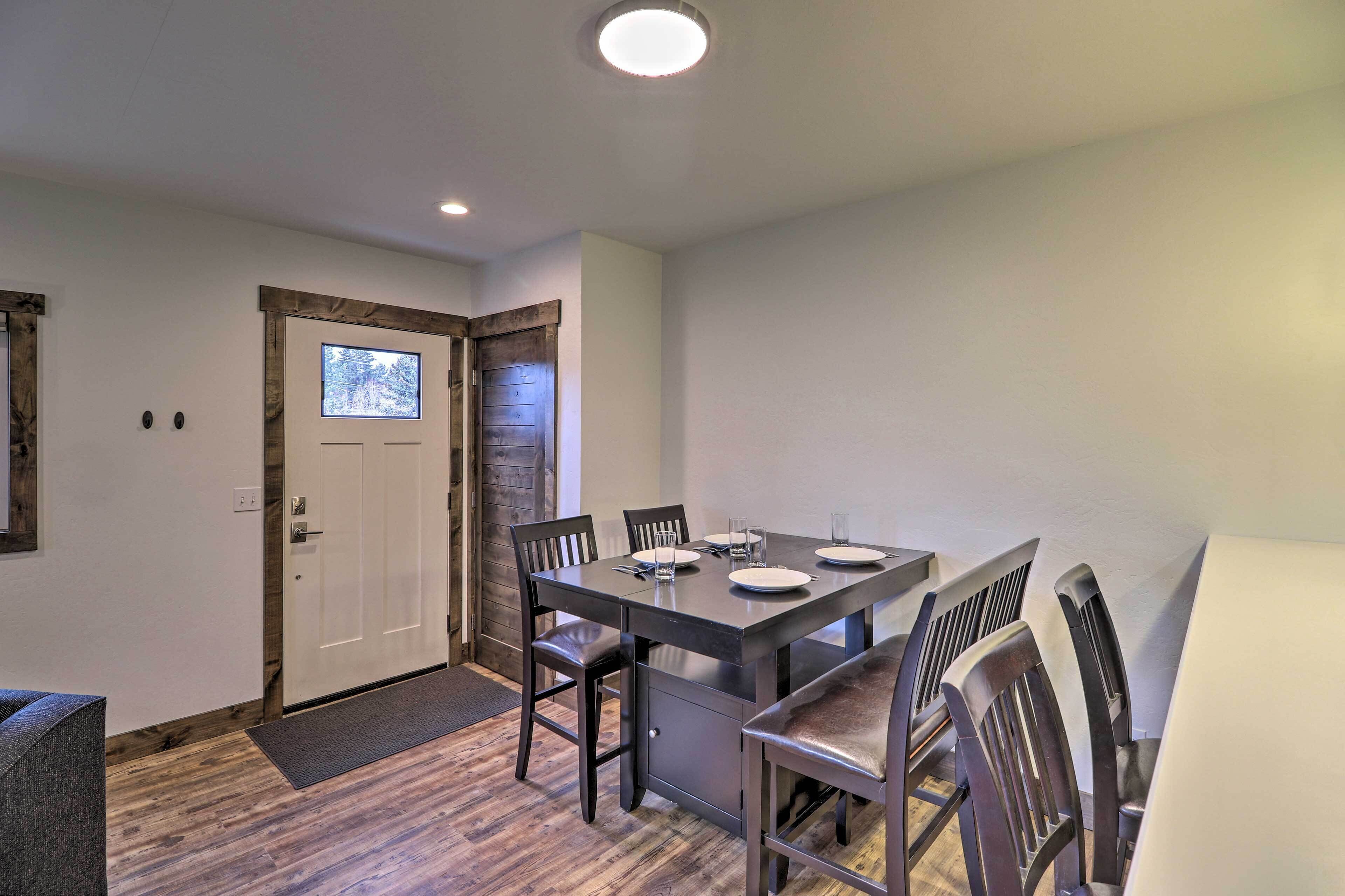 A dining area with a rectangular table, six chairs, and a wooden door with a window.