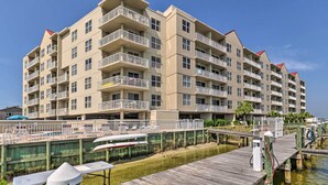 Un hôtel à plusieurs étages doté de balcons, d’un espace piscine et d’un quai.