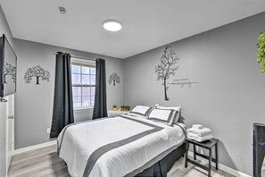 A bedroom with a bed, a nightstand, a window with curtains, and wall art. - Modern Nashville Home ~ 10 Mi to Music Row (Nashville)