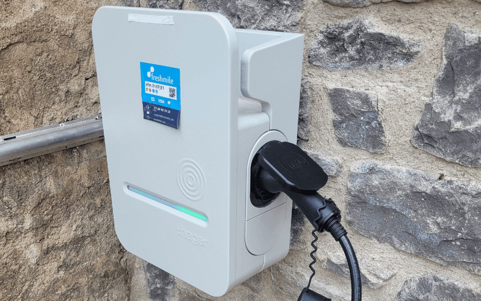 Une borne de recharge portant une étiquette indiquant « freshmile » et un code QR.