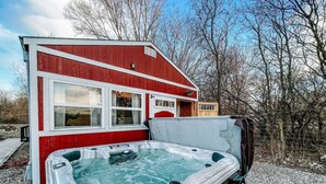 Una caravana roja y blanca con un jacuzzi adjunto.
