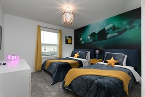 Een slaapkamer met twee bedden, een bureau, een neonbord en een groot muurschildering.