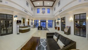 Eine geräumige Lobby mit Empfangsschalter, Sitzgelegenheiten und großen Fenstern.