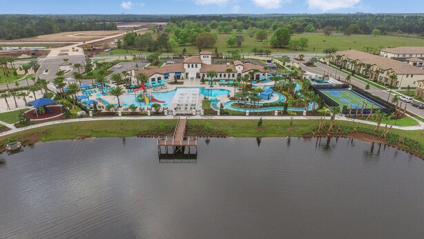 Ein Resort mit großem Schwimmbad, Tennisplatz und Steg am See.