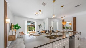 A modern kitchen with a central island, stainless steel appliances, and pendant lighting. - Last Minute Disney Getaway! Townhouse with Private Pool. Book Now! #98615 (Orlando)
