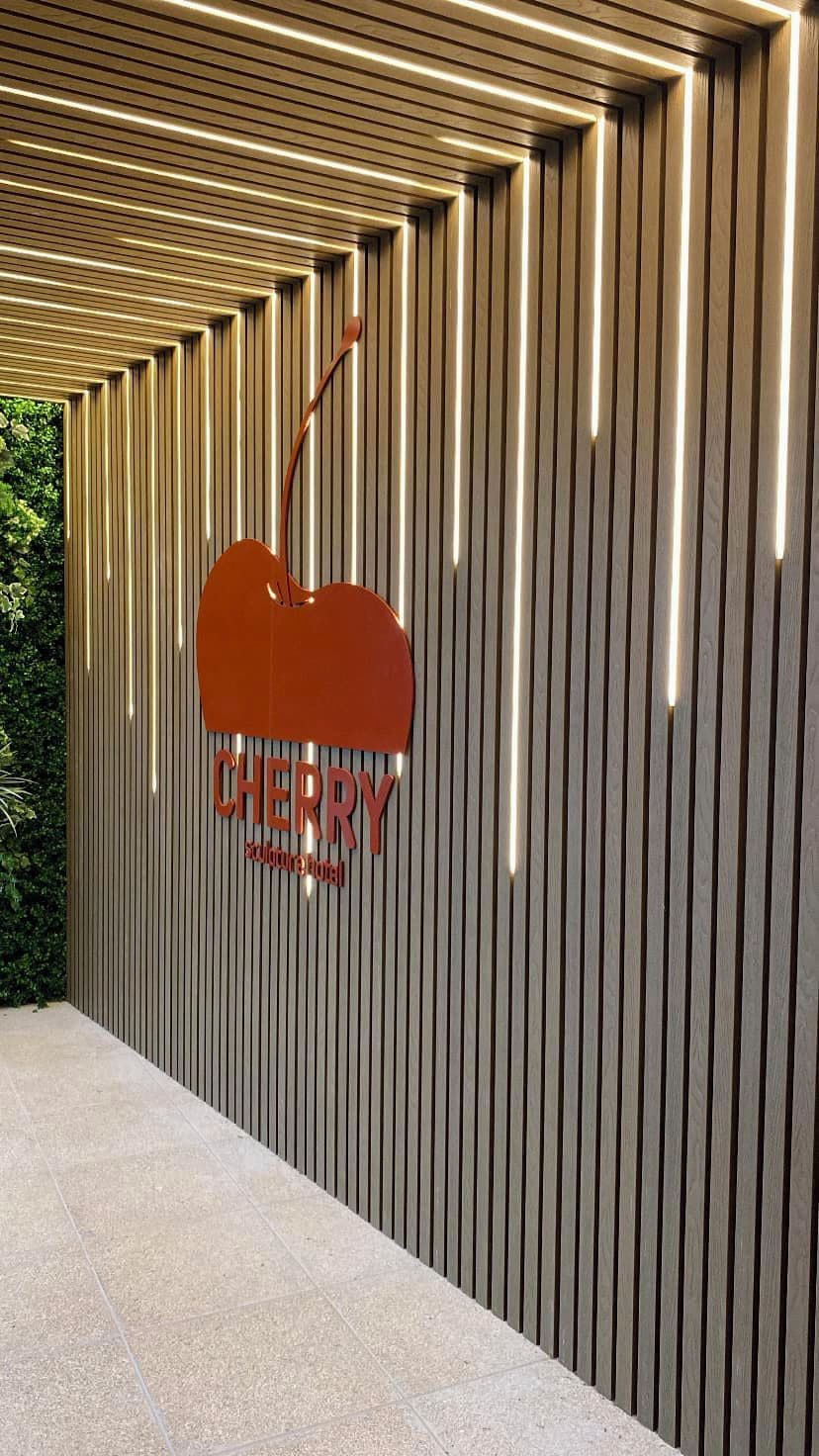 A wall with vertical slats and a hanging sign that reads 'CHERRY.'