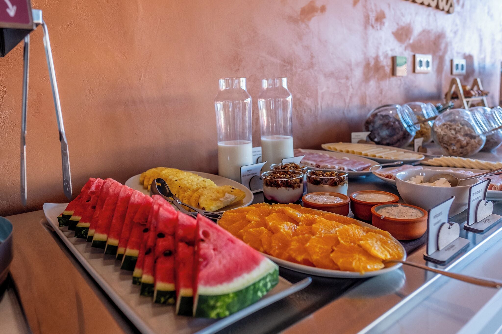 Ein Frühstücksbuffet mit verschiedenen Früchten, Joghurt und Müsli.