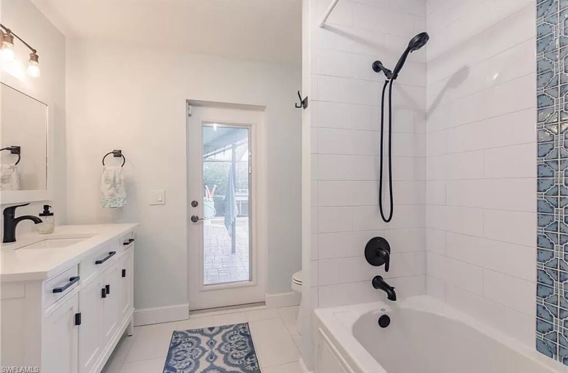 Une salle de bain moderne avec un meuble-lavabo blanc, une baignoire et une douche.