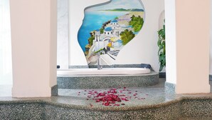 Uma escadaria com design único, um mural e pétalas de rosas espalhadas.