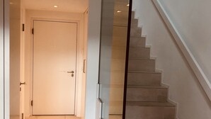 Een modern interieur met een trap, een deur en een tafel met documenten.