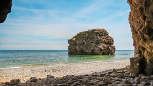 A rocky coastline with a prominent rock formation in the center, a clear sky, and a calm sea. - 6 Guests - 3 Bed House in Chester-le-street (Chester-le-Street)