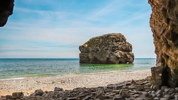 A rocky coastline with a prominent rock formation in the center, a clear sky, and a calm sea. - 6 Guests - 3 Bed House in Chester-le-street (Chester-le-Street)