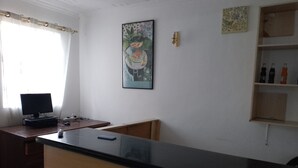 A reception desk with a computer, a telephone, and a sign indicating card payment acceptance. - Nairobi Transit Lounge (Syokimau)