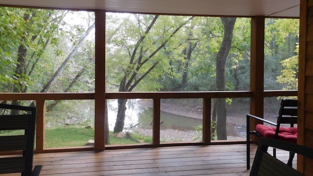 A wooden deck with a view of a forest and a body of water. - Triplett Creek Cabin Rental with Scenic Views  – Near Cave Run Lake! (Morehead)