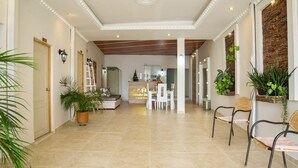 Eine großzügige Hotelhalle mit Rezeption, Sitzgelegenheiten und Zimmerpflanzen.